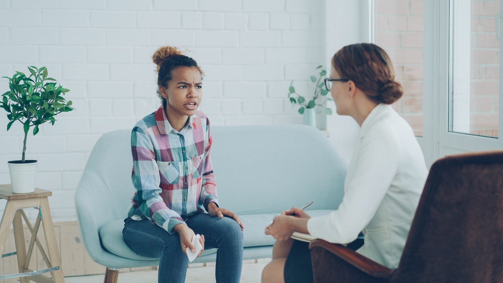 A woman talks to a therapist in an office.